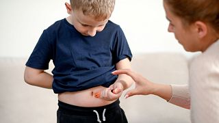 A child injects insulin.
