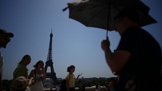 People walk at Trocadero plaza near Eiffel Tower during a heatwave on 2 July. 