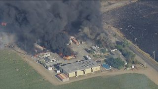 Smoke and flames rise at a fireworks warehouse near Esparto, Calif., on Tuesday, July 1, 2025. 