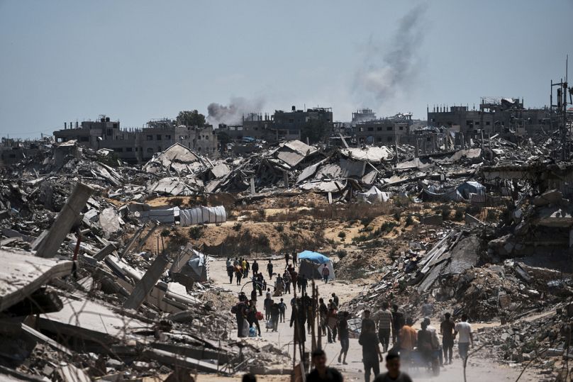 فلسطينيون نازحون يعودون لجمع ما تبقّى من ممتلكاتهم في منطقة شمال غزة، في 4 حزيران/يونيو 2025.