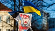A demonstrator holds a Ukrainian and Estonian national flags with a poster attending rally in support of Ukraine, in Tallinn, Estonia, Saturday, Feb. 26, 2022