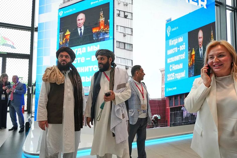 Mitglieder der Taliban stehen vor Fernsehbildschirmen, am Internationalen Wirtschaftsforum von St. Petersburg, Russland, teilnehmen, Mittwoch, 18. Juni 2025