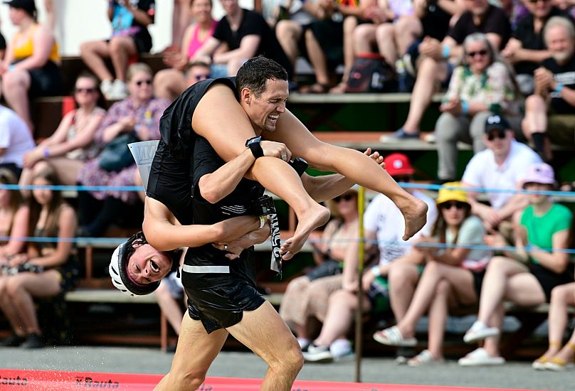 Finland's Nate Buchanan carrying Kara Buchanan in the Wife Carrying World Championships in Sonkajarvi, Finland - Saturday 2 July 2022