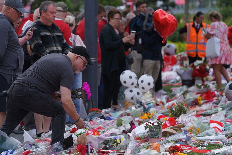 Des fans déposent des fleurs, des écharpes et d'autres objets à Anfield