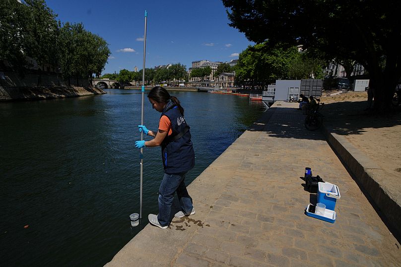 Emilie Vilana of Fluidion collects a water sample from the Seine ahead of the 5 July opening of three public swimming sites for Paris Plages.
