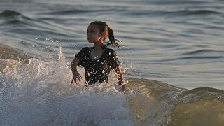 A Palestinian girl cools off in the Mediterranean Sea during a heat wave in Gaza City, Wednesday, July 2, 2025.