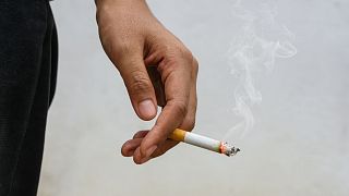 A person holds a cigarette.