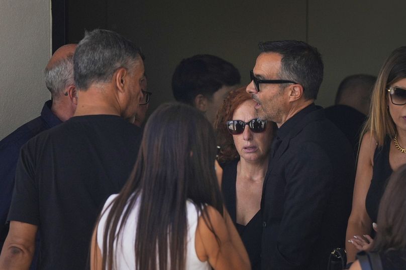 Isabel, la mère des attaquants de Liverpool Diogo Jota et Andre Silva, accompagnée de l'agent de football Jorge Mendes, à droite, quitte une église.
