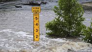 A flood gauge marks the height of water flowing over a farm-to-market road near Kerrville, Texas, on Friday, July 4, 2025.