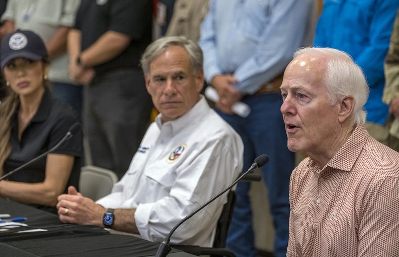 Ο γερουσιαστής John Cornyn, δεξιά, μιλάει στους δημοσιογράφους , η υπ. Εσωτερικής Ασφάλειας Kristi Noem και ο κυβερνήτης Greg Abbott, παρακολουθούν