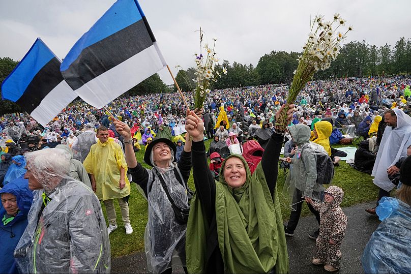 Spectators wave Estonian flags and bouquets of flowers during the song festival in Tallinn, 6 July, 2025.