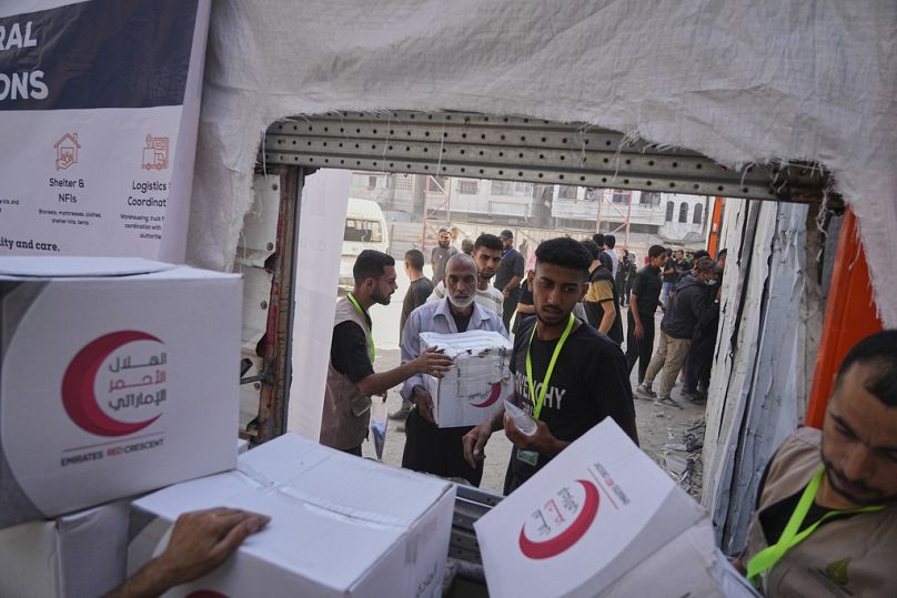 Filistinliler, Gazze Şeridi'nde Amerikan Yakın Doğu Mülteci Yardımı tarafından dağıtılan gıda paketlerini teslim alıyor, 26 Haziran 2025.