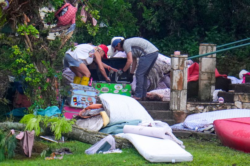 Personas revisan sus pertenencias en un baúl en el Campamento Mystic, a orillas del río Guadalupe, después de que una inundación arrasara la zona el 6 de julio de 2025.