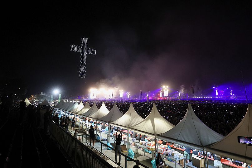 A cross illuminates the concert