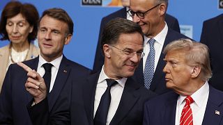 President Donald Trump, right, speaks with NATO Secretary General Mark Rutte during a group photo of NATO heads of state and government at the NATO summit in The Hague