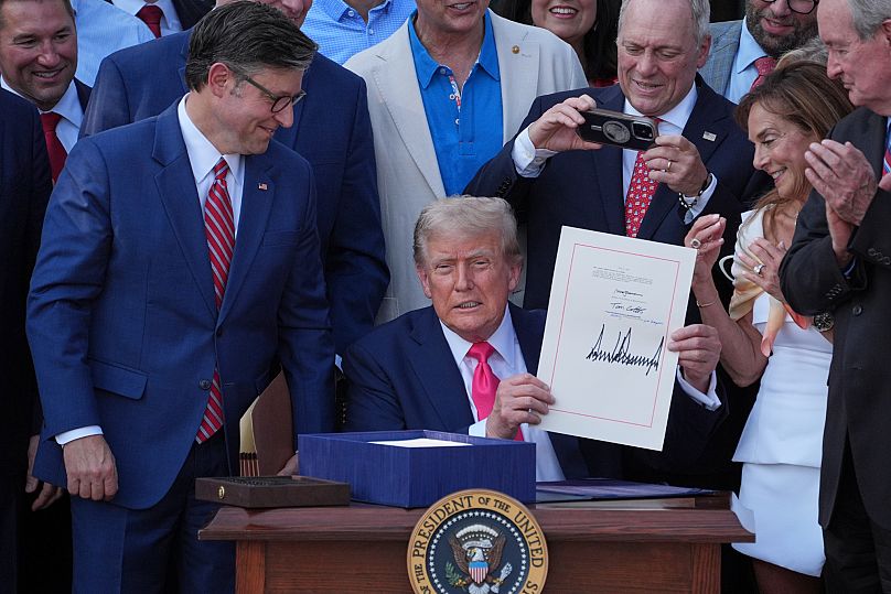 Le président américain Donald Trump montre son projet de loi budgétaire à la Maison Blanche, le vendredi 4 juillet 2025, à Washington