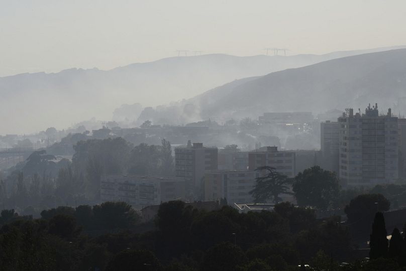 La fumée s'élève derrière les bâtiments lors de l'incendie de forêt, dans le quartier de La Castellane.