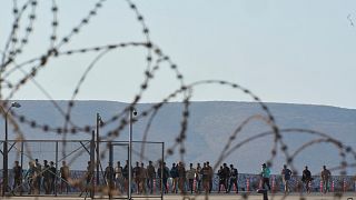 Migrants rescued south of Crete walk after their arrival at the the port of Lavrio, 10 July, 2025