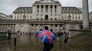 A woman with an umbrella stands in front of the Bank of England, at the financial district in London. 3 November 2022.