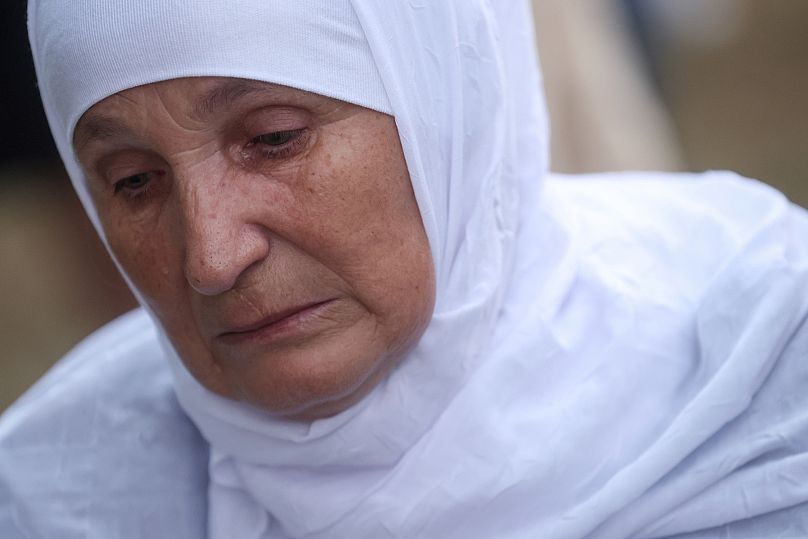 Frau trauert neben dem Sarg ihres Verwandten, der 1995 dem Völkermord in Srebrenica zum Opfer fiel.