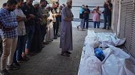 Palestinians pray over the bodies of 10 people, including two women and five children, killed in an Israeli strike while they were waiting to receive nutritional supplements a