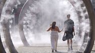 A couple walk through a cooling water feature as the third heatwave of the summer hits the UK, in Dover, 11 July 2025. 