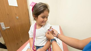 A girl receives a bandage after getting a vaccine.