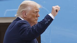 President Donald Trump gestures from the stairs of Air Force One as he boards upon his arrival at Joint Base Andrews, Md., 15 July, 2025. 