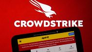 The logo for CrowdStrike and a Spirit Airlines webpage are shown on a computer screen and mobile phone screen, in New York, Friday, July 19, 2024