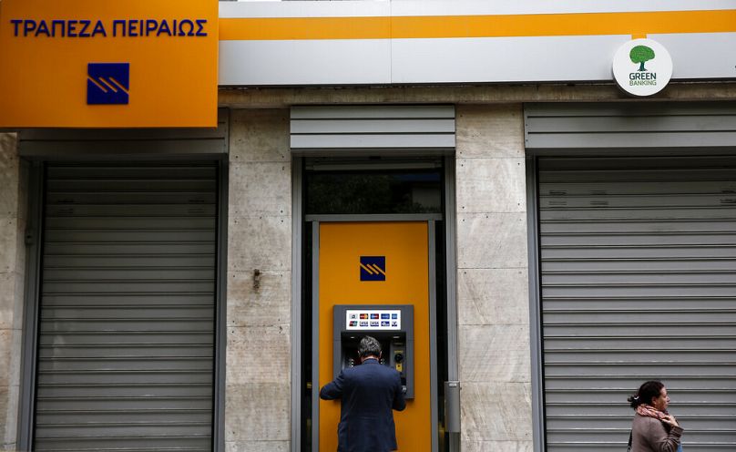 A man uses an ATM in Greece