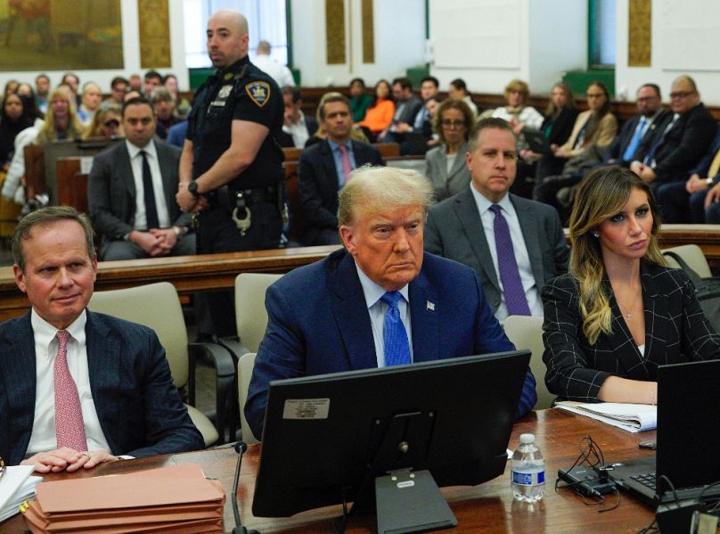 Donald Trump a New York-i bíróságon ügyvédei között; a balján Alina Habba