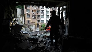Un residente de pie en el apartamento dañado en una casa de varios pisos después de un ataque ruso en Kiev, Ucrania, Lunes, 21 de julio 2025.