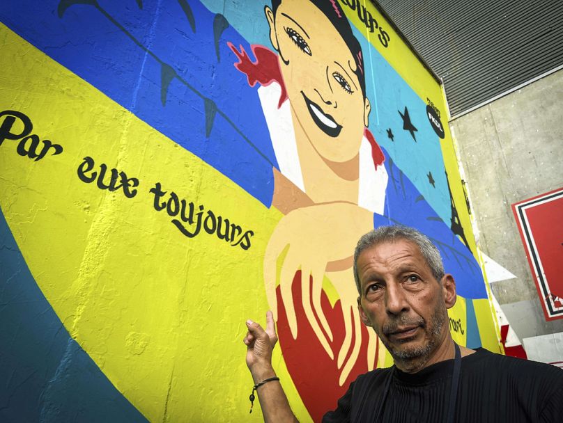 Brian Baker, son of U.S.-French entertainer and civil rights activist Josephine Baker, stands in front of a new mural of his mother painted by artist Franck Duval, aka FKDL