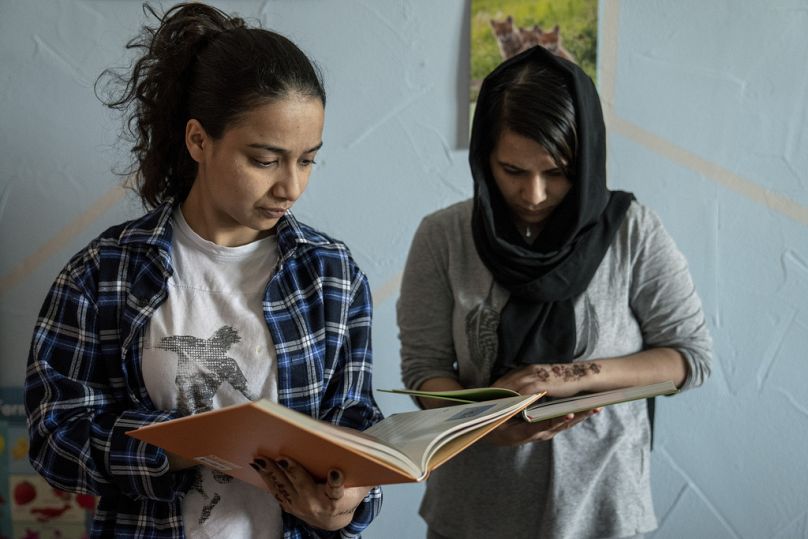 April 2024: Zwei afghanische Asylbewerberinnen lesen am Mittwoch in der Bibliothek einer Flüchtlingsunterkunft (Symbolbild).