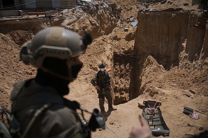 Israeli soldiers stand next to an entrance of a tunnel under the European Hospital in Khan Younis in southern Gaza, 8 June, 2025