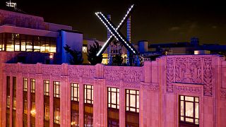 Workers install lighting on an "X" sign atop the company headquarters, formerly known as Twitter, in downtown San Francisco, on Friday, July 28, 2023.