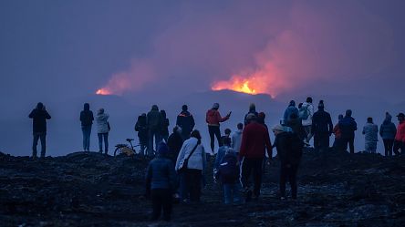 Tourists watch cooling lava as Iceland’s volcanic activity slows