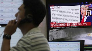A currency trader works near the screen showing news reporting with a picture of President Donald Trump, in the Hana Bank headquarters in Seoul, South Korea, 23 July 2025.