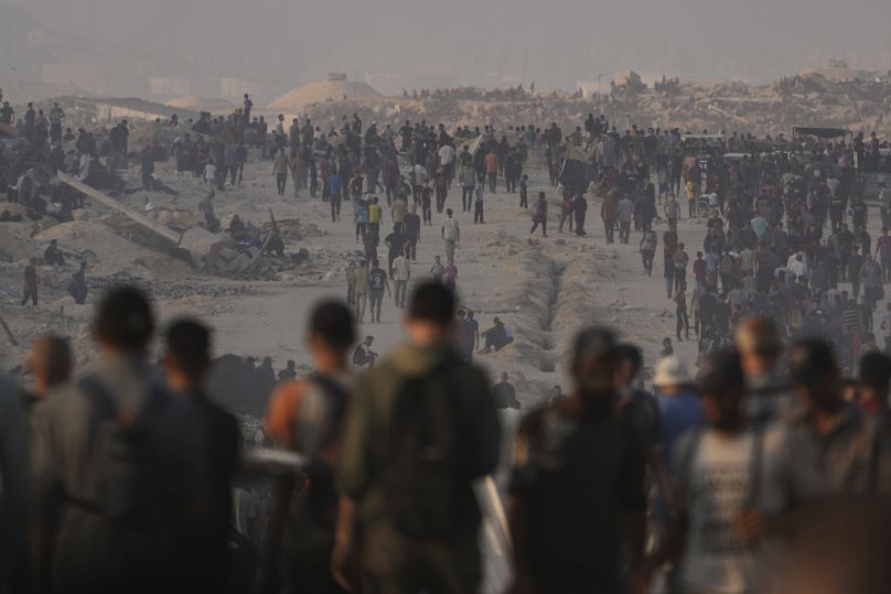 فلسطينيون يسيرون على طريق باتجاه منطقة في شمال قطاع غزة تدخل فيها شاحنات بمساعدات إنسانية ، في مدينة غزة ، الجمعة 25 تموز / يوليو 2025.