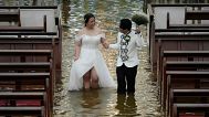 Newlyweds Jade Rick Verdillo and Jamaica walk hand in hand during their wedding at the flooded Barasoain church in Malolos, Bulacan province, Philippines, 22.07.2025