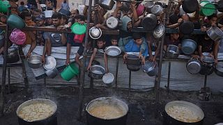 Palestinians struggle to get donated food at a community kitchen in Gaza City, 14 July, 2025