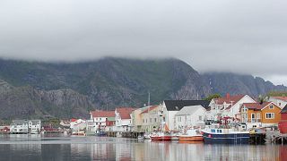 A Norwegian fishing village, hidden in the fjords, under a dense fog. 