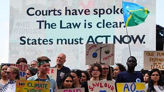 Activists demonstrate outside the International Court of Justice ahead of an advisory opinion.