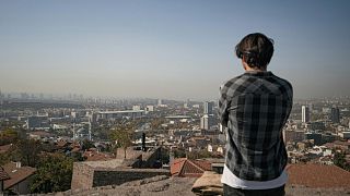 A man looks over a smoggy city.
