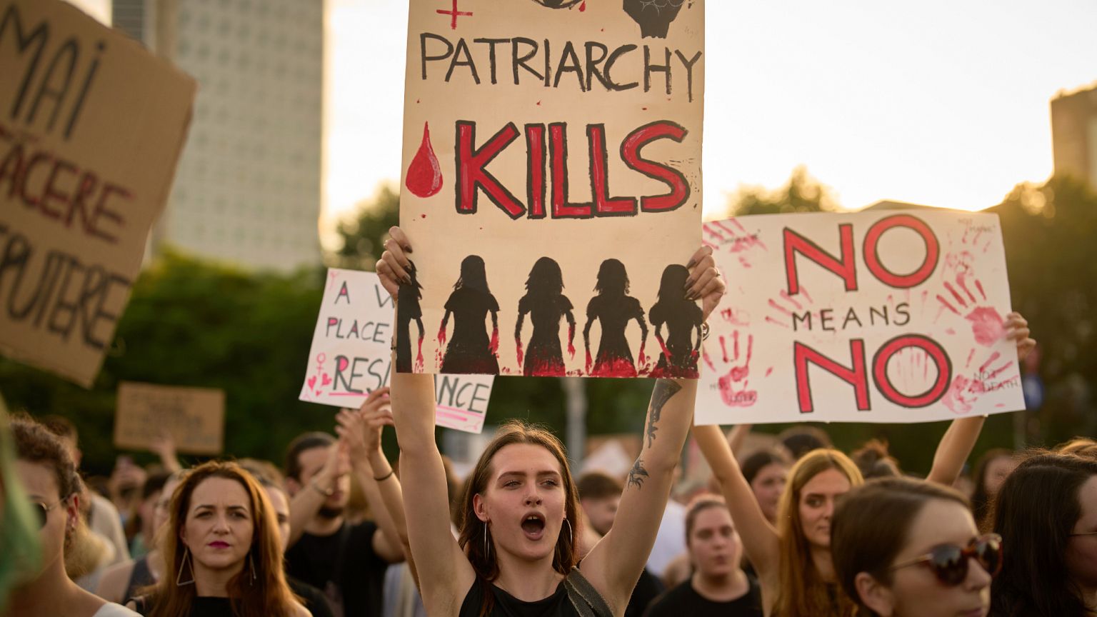 People hold banners during a protest joined by thousands of women's rights activists the government headquarters in Romania.