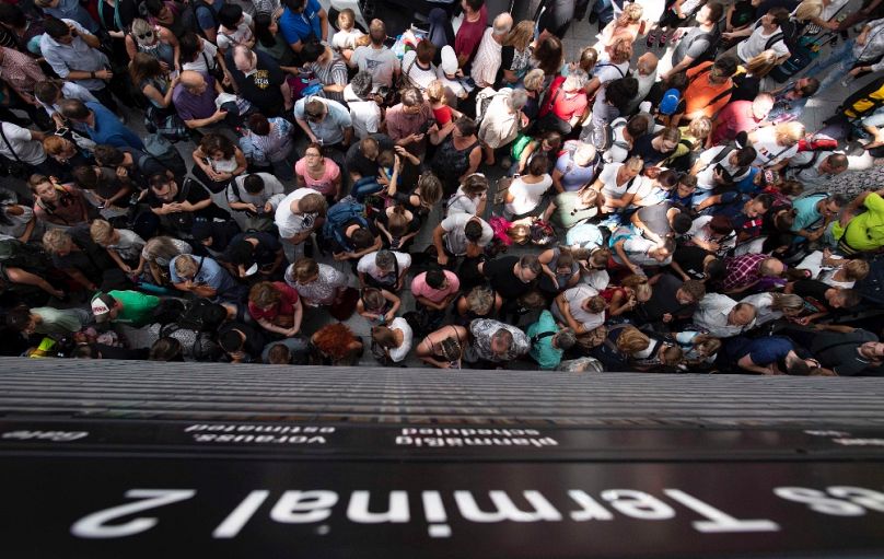 Biztonsági ellenőrzésre váró utasok a müncheni repülőtéren, 2018 júliusában