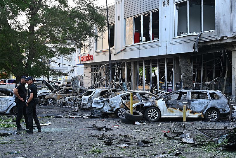 Des policiers inspectent des voitures endommagées dans un quartier résidentiel après une attaque de drones russe à Odessa, en Ukraine, le mardi 22 juillet 2025