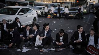 Ultra-Orthodox Jewish men block traffic during a protest against army recruitment in Jerusalem, Wednesday, July 23, 2025.