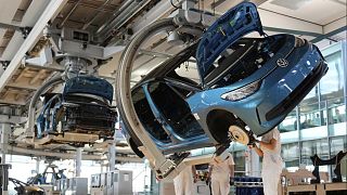 Employees of the German car manufacturer Volkswagen assemble an ID.3 electric car at the transparent factory in Dresden, Germany, Wednesday, May 14, 2025.