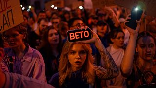 A woman holds a phone with a sign reads "Veto" during the protest against the law aimed towards regulations of anti-corruption institutions in central Kyiv, 22 July 2025